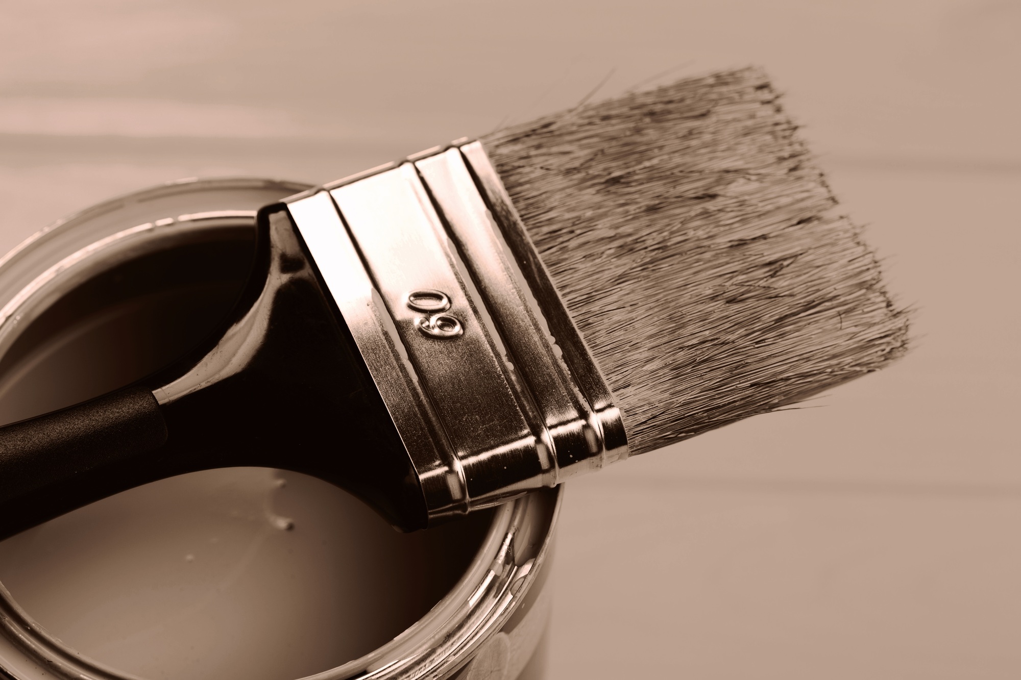 Paintbrush balanced on a can, showcasing the warm tone of paint