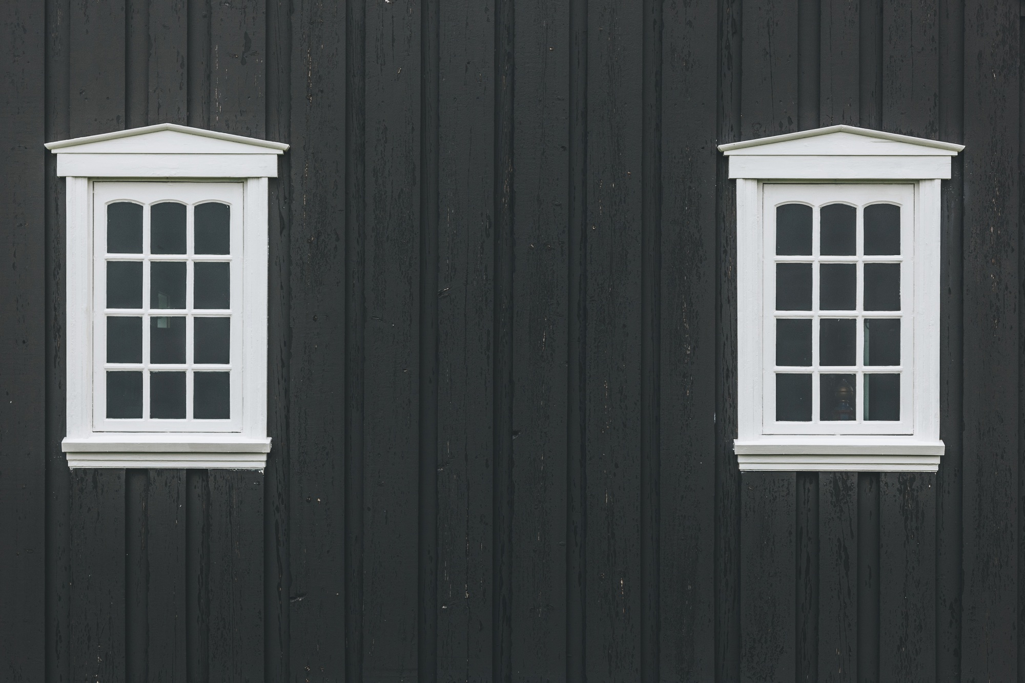 white windows on old black building facade