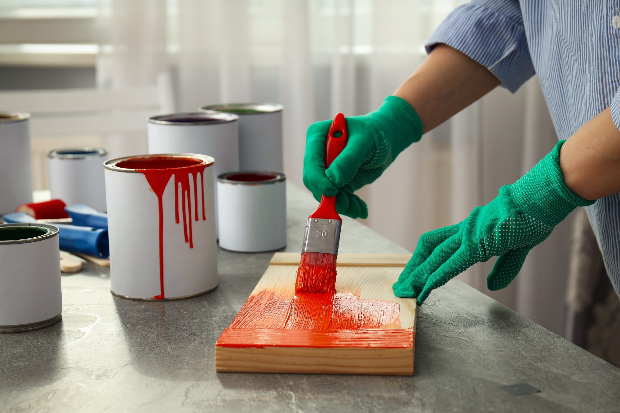 Woman paints board with brush, close up