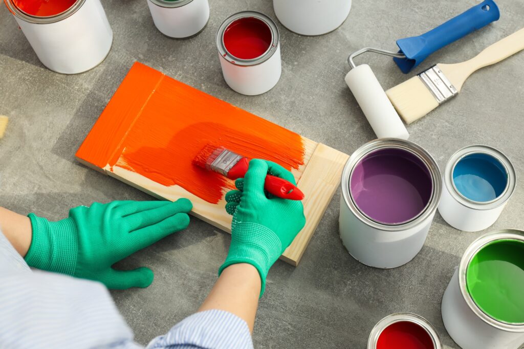 Woman paints board with brush, close up